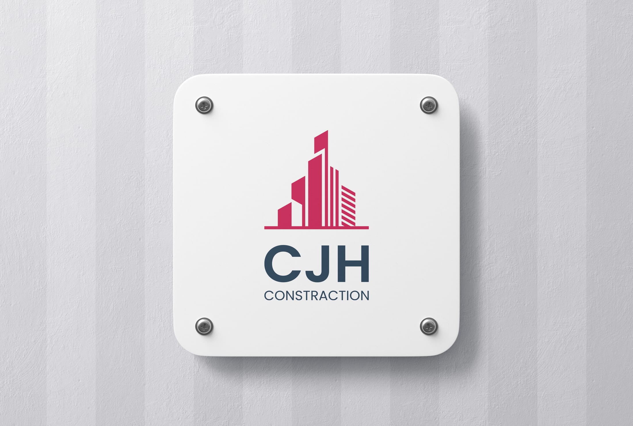 CJH Construction logo mounted on a white wall sign